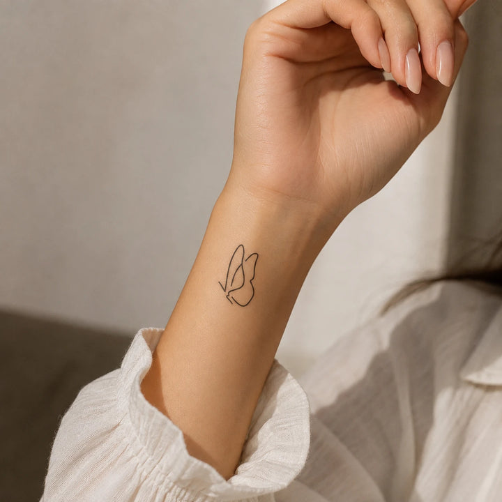 Butterfly charm Tattoo on the women arm near wrist