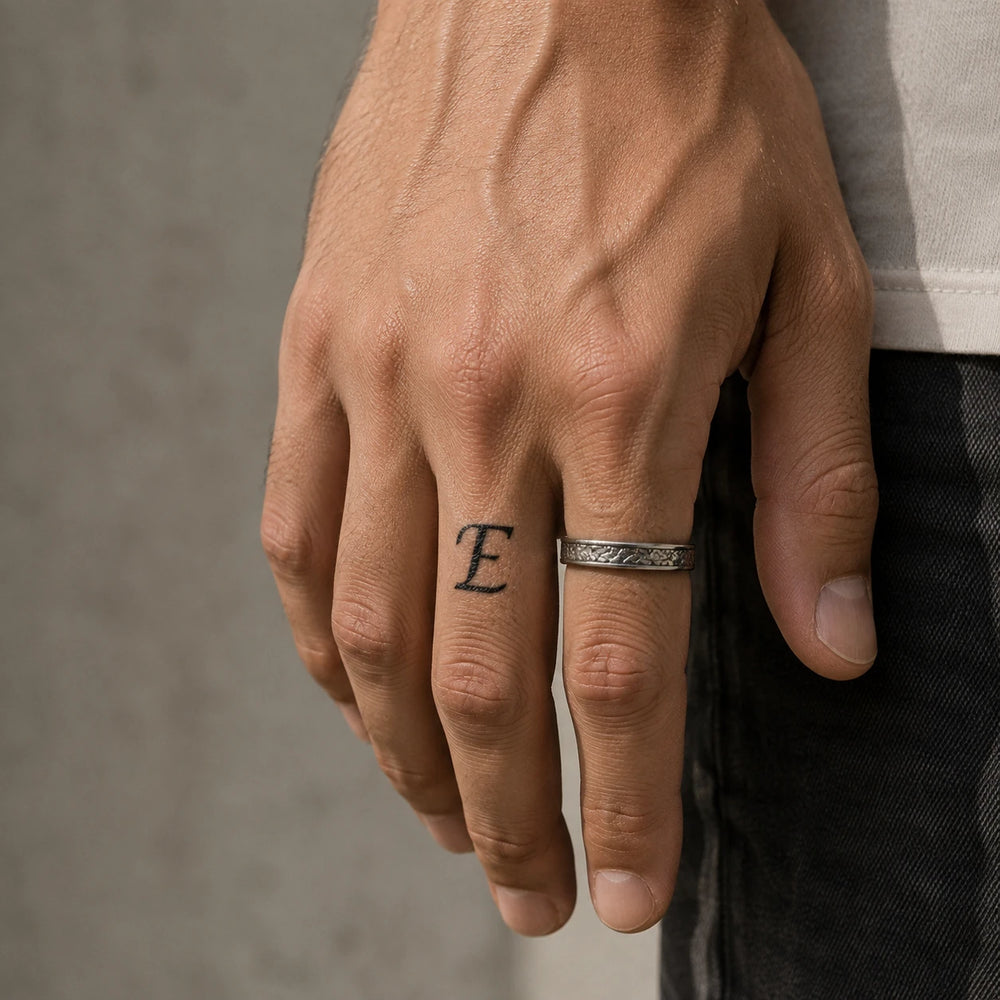 E Letter Tattoo on man hand